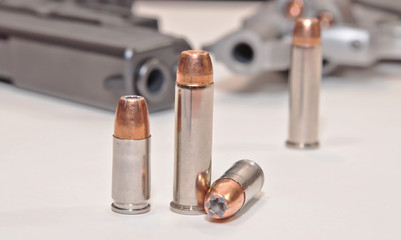  Four bullets, two 9mm and two .357 magnum with a stainless .357 revolver and a black 9mm pistol in...