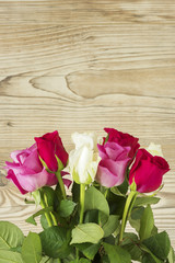 Fototapeta na wymiar Ein Blumenstrauß mit Rosen vor einem Holz Hintergrund