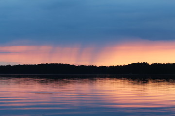 Sunset on the Vuoksa lake. It is small rain on the horizon.
