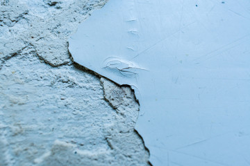 Fototapeta premium Grey surface with pieces of peel-off paint and putty. Selective focus and copy space.