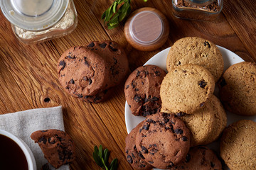 Coffee cup, jar with coffee beans, cookies over rustic background, selective focus, close-up, top view