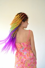 Fototapeta na wymiar Девушка с длинным волнистым волосом окрашенный в разноцветные яркие радужные цвета. Канекалон штучный волос