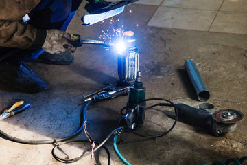 welder welds pipe on corrugation muffler