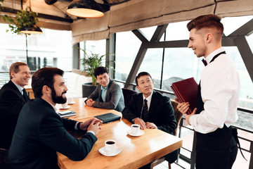 Meeting with chinese businessmen in restaurant. Men are making their order.
