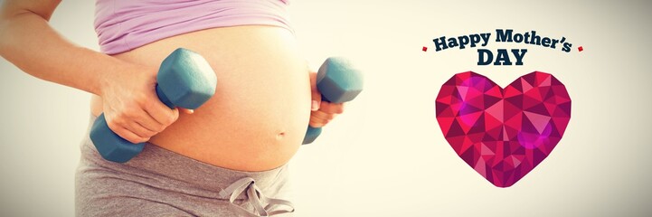 Naklejka na ściany i meble Composite image of pregnant woman holding dumbbells 