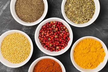 Various spices in bowls on black background. Top view. Food background