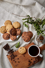 Fototapeta na wymiar Coffee cup, jar with coffee beans, cookies over rustic background, selective focus, close-up, top view