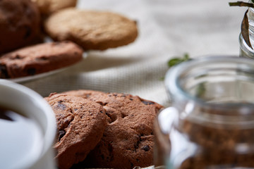Breakfast background with mug of fresh coffee, homemade oatmeal cookies, grind coffee