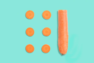 top view of sliced carrot on green toned background, stringed in orderly fashion, artistically arranged