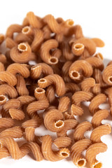 Braune Vollkornnudeln in Spirfalform isoliert auf weißem Hintergrund