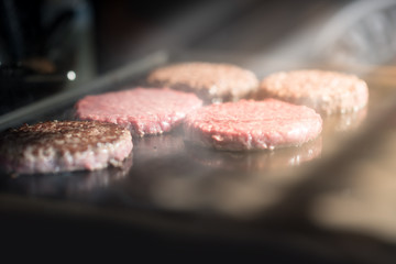 Hamburger cutlet frying on pan.Natural meet loaf pieces cooking in the kitchen.Burger sandwich meat being cooked with a lot of white smoke from a fat and oil.