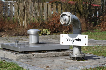 Saugrohr für die Feuerwehr neben einer neu errichteten Edelstahl-Quellfassung in der Talaue im...