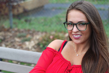 young women with glasses red dress sitting in the park attractive lady pretty portrait elegance people