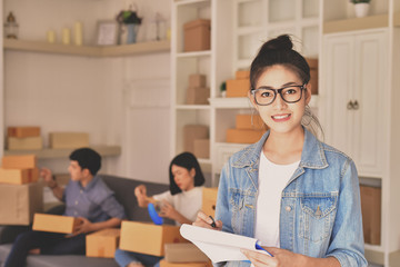 Fototapeta premium Sme business concept. Young Asian people are packing their packages.Delivery business Small and Medium Enterprise (SMEs). Young man is working in the house.Young Owner Start up for Business Online.