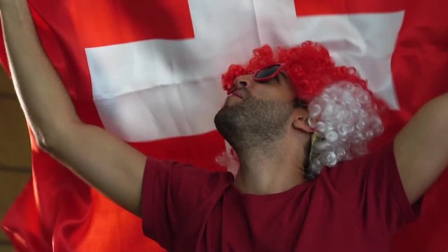 Swiss fan celebrating with flag