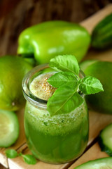 Green cocktail in a glass jar sprinkled with brans decorated with basil