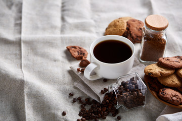 Breakfast background with mug of fresh coffee, homemade oatmeal cookies, grind coffee