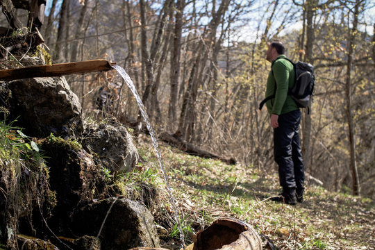 Young hiker drinking the mountain spring water