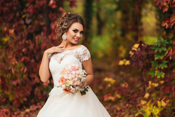 Fototapeta na wymiar Portrait of a smiling bride in an autumn forest