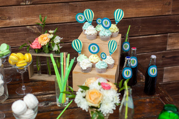 Candy bar. Cakes, drinks and treats stand on a wooden table. Summer party