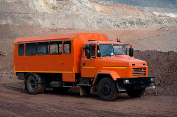 Orange car to transport workers in the ore quarry to workplaces. Ukrainian truck.