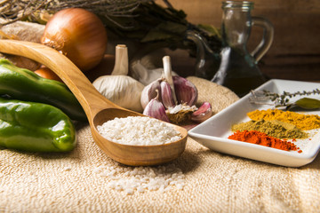 Still life with the ingredients to make a rice stew with vegetables and spices.