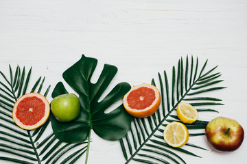 Composition with tropical leaves and frech fruits on light background