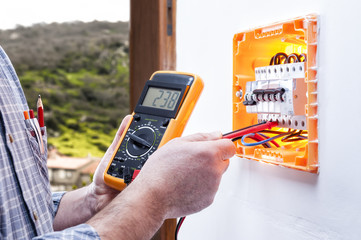 Electrician technician repairs the electrical panel of a residential system