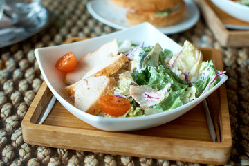 Caesar salad is on the plate in a restaurant.
