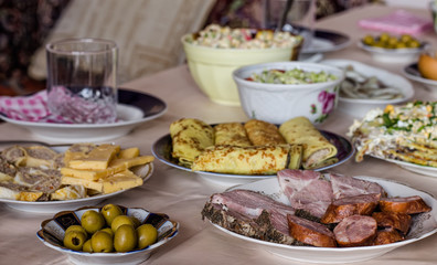 Festive dinner (smoked sausage with pepper and garlic, ham with pepper, marinated green olives, Dutch cheese, pancakes with meat, mushroom pie, salads etc.)