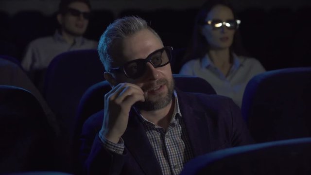 terrified man watches a horror film at the cinema