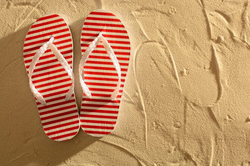 Flip flops on a sandy beach, sunset, top view