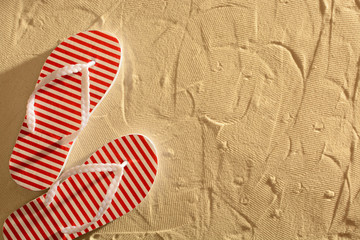 Flip flops on a sandy beach, sunset, top view