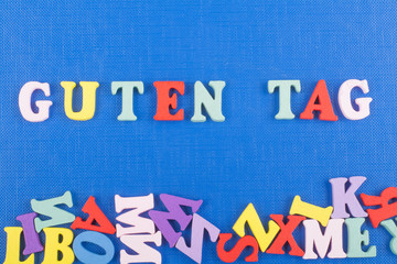 GUTEN TAG GOOD DAY word on blue background composed from colorful abc alphabet block wooden letters, copy space for ad text. Learning english concept.
