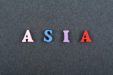 ASIA word on black board background composed from colorful abc alphabet block wooden letters, copy space for ad text. Learning english concept.