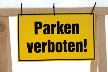 gelbes Schild mit Aufschrift Parken verboten 