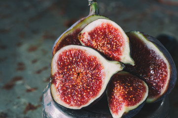 Sweet red ripe figs on a bunch of lies on the stand .