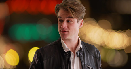 Caucasian male waiting nervously for date to arrive outdoors in evening