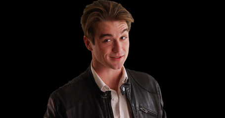 Male in leather jacket winking at camera on black background with copyspace