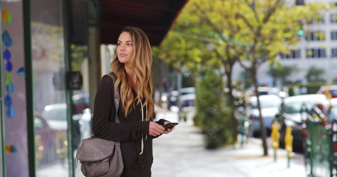 Millennial Girl Waiting Outside Restaurant Messaging On Cell Phone Downtown