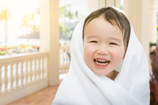 Happy Cute Mixed Race Chinese and Caucasian Boy On Tropical Patio Wrapped In A Towel