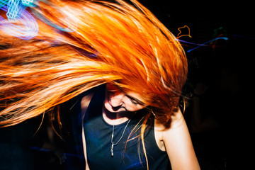 Fototapeta premium Girl are having fun on the weekends, dancing at the disco. Light music.