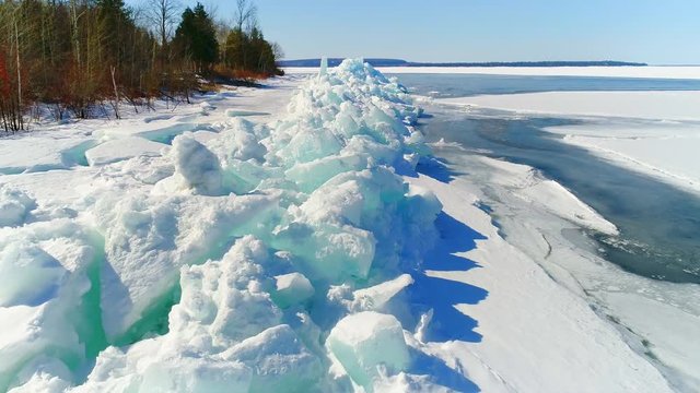 Low aerial flight over scenic, surreal jagged ice shoves on the shore of Door County Wisconsin; created by high winds in Springtime which heaves and cracks the thick ice on the rocky shores.