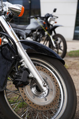 Obraz premium Two motorcycles. Close-up of the front wheel, brake disc, shock absorbers.