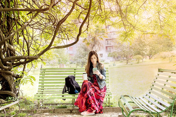 Young woman in the park sitting on a bench