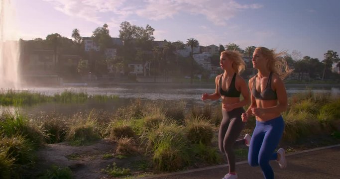 Athletic Twins Working Out. Running in a beautiful park at sunrise.