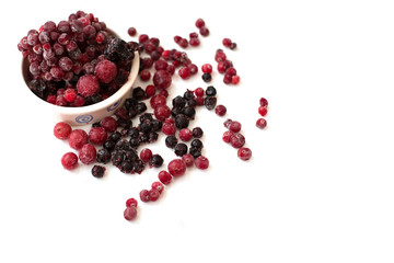 Bright frozen cherries, cranberry, blueberries are full of vitamins for a healthy diet and active life on a white background in a white plate