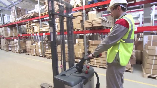 warehouse worker on forklift transporting cargo