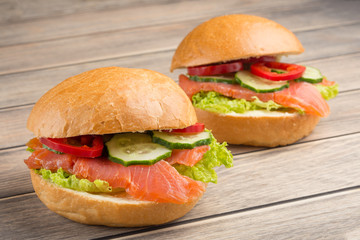 Sandwich with red fish and vegetables, on a wooden background. Concept of healthy food, diet.