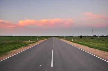 Fototapeta premium Asphalt road and beautiful cloudy sky at sunset